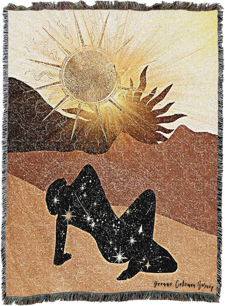 Blanket with a design of a sun, silhouette of a person, and constellation on a desert landscape.