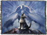 Tapestry blanket showing wolf cub howling, more wolves formed of clouds in the sky