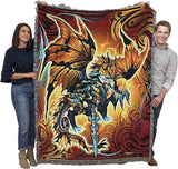 Tapestry blanket with dragon and sword. Dragon is done in shades of bronze, brown, black, blue, white, gray. Tribal designs surround it. Shown held by two adults