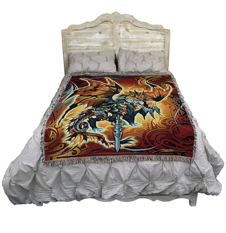 Tapestry blanket with dragon and sword. Dragon is done in shades of bronze, brown, black, blue, white, gray. Tribal designs surround it. Shown on a bed