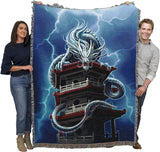 Tapestry blanket with Asian style dragon on a pagoda tower with lightning. Shown held by two adults