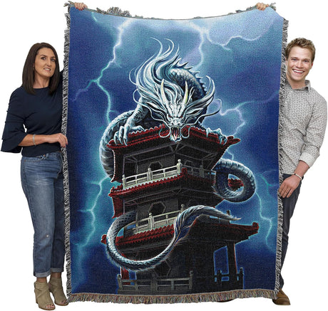 Tapestry blanket with Asian style dragon on a pagoda tower with lightning. Shown held by two adults