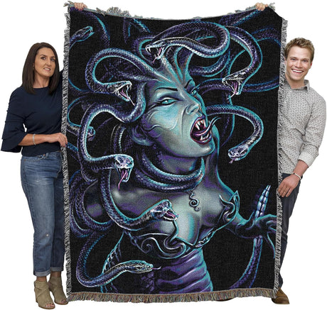 People holding a large blanket with a Medusa design