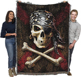 Tapestry blanket showing a skull and crossbones in pirate bandana with eyepatch, earring hoop, and doubloons. Shown held by two adults