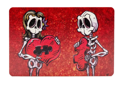 Magnet with two skeletons, one holding a heart with missing section and the other holding the puzzle piece that fits inside