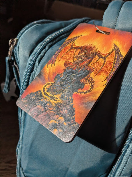 Blue bag with a dragon-themed luggage tag featuring an orange and red background.