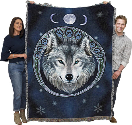 Two people holding a blanket with a wolf design and moon phases.