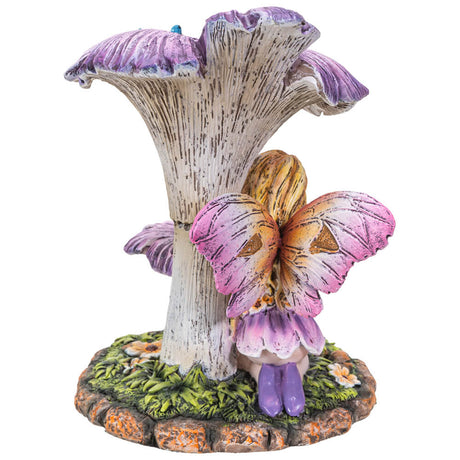 Blond pixie with pink and yellow wings sits under purple flowers with two blue birds. Shown from the back