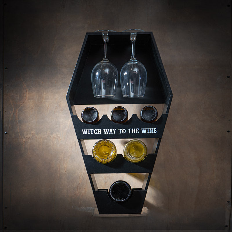 Wine rack in black, coffin shape, with text "Witch way to the wine", shown with wine and glasses