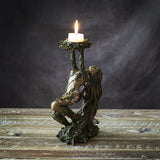 Candle holder shaped like an ent tree-woman/nymph, arms and hands reaching up to form holder, shown with candle