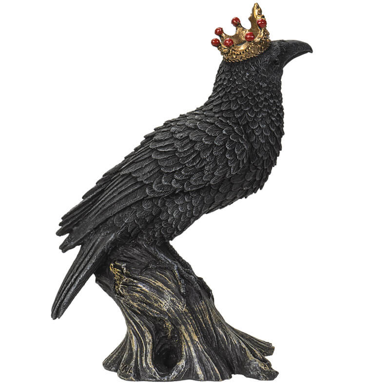 Figurine of a black crow on a branch wearing a golden crown with red accents