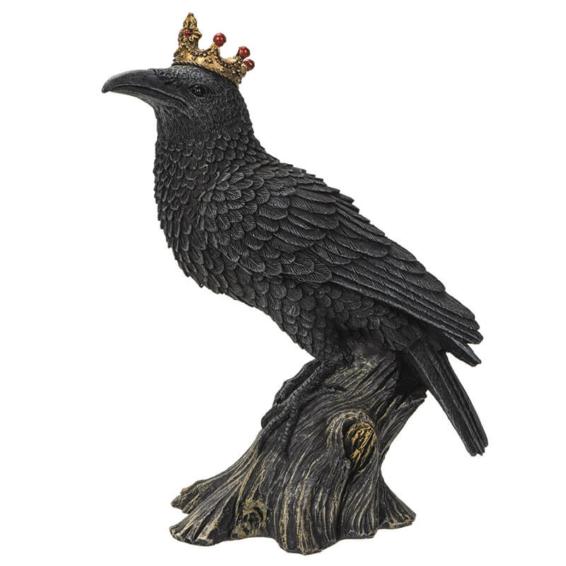 Figurine of a black crow on a branch wearing a golden crown with red accents