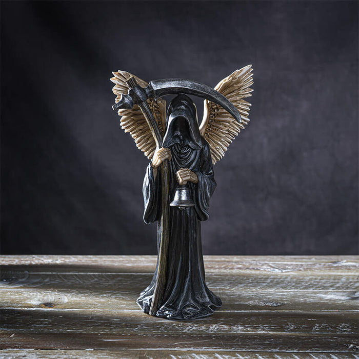 Figurine of a grim reaper in black with scythe and bell