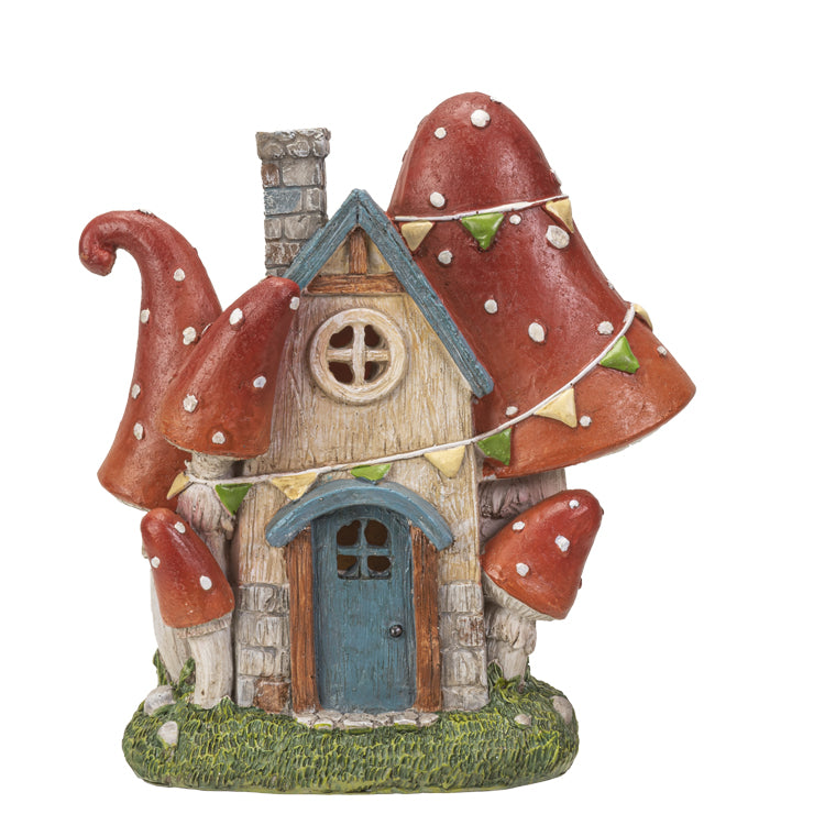 Garden figurine of house surrounded by red and white dotted mushrooms