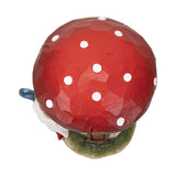 Figurine of mushroom house with windows and gnome in blue and red