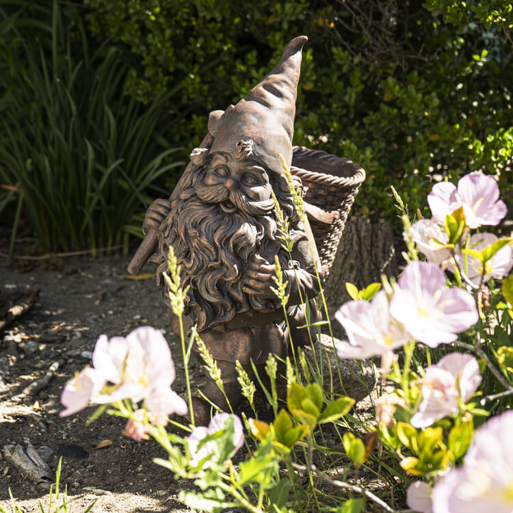 Bronze garden gnome with pickaxe and basket on his back, floral planter