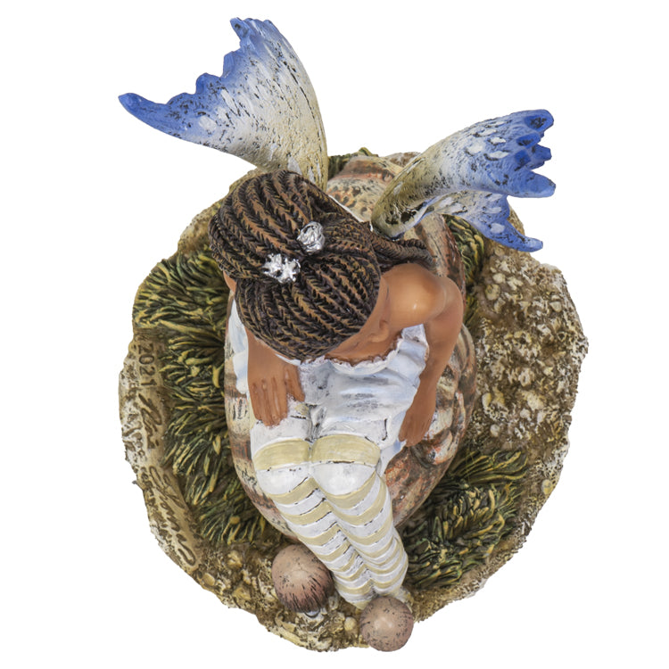 Fairy figurine by Amy Brown, pixie sitting on snail shell, blue tinged wings and striped stockings, top down view