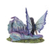 Figurine of a dragon with purple and blue napping on a fairy in a teal dress with black-purple hair. Back view