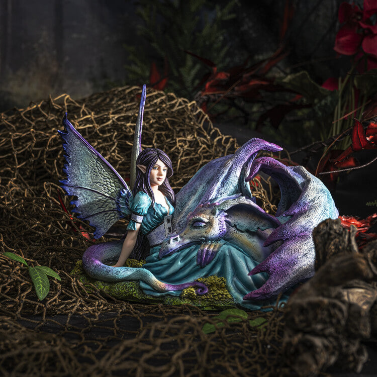 Figurine of a dragon with purple and blue napping on a fairy in a teal dress with black-purple hair