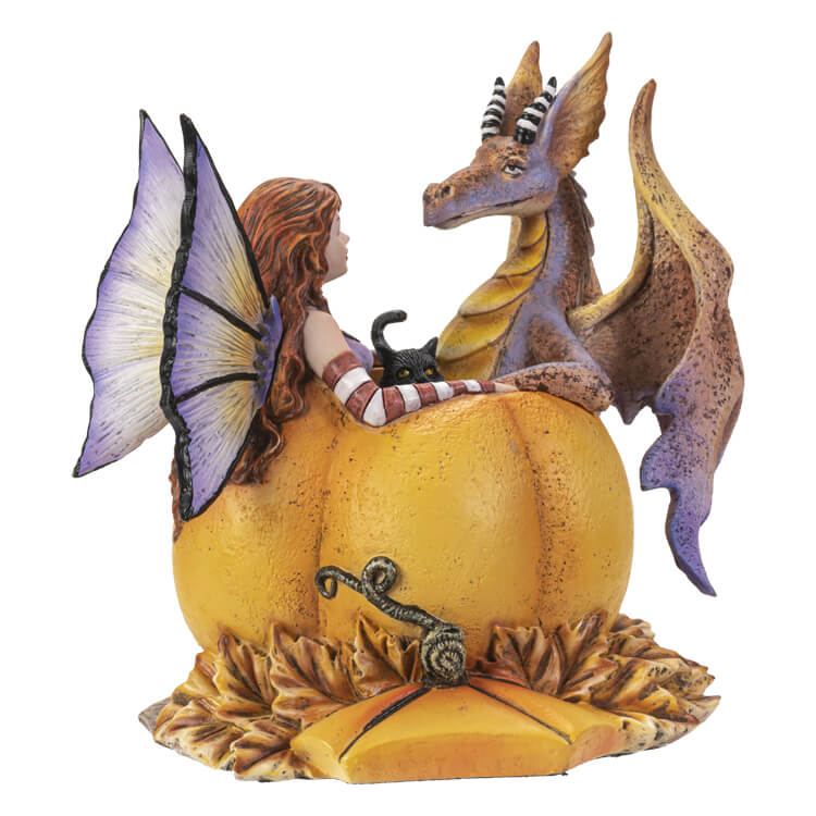 Fairy with red hair, black cat, and orange-purple dragon sitting in a bright orange pumpkin amidst fall leaves