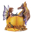 Fairy with red hair, black cat, and orange-purple dragon sitting in a bright orange pumpkin amidst fall leaves