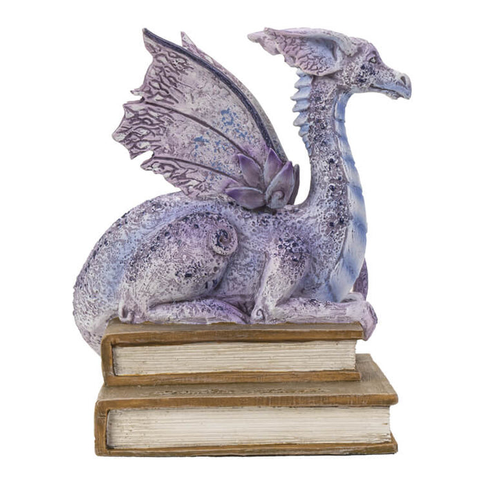 Figurine of a pale purple dragon perched on two books