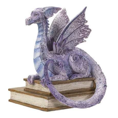 Figurine of a pale purple dragon perched on two books