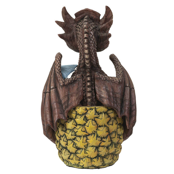 Mai Tai dragon  with brown scales sitting in pineapple holding a cherry, with a blue drink umbrella. Shown from the back