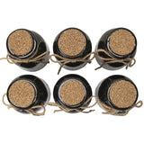 Set of six black bottles with cork lids and hazard symbol labels. Shown top down