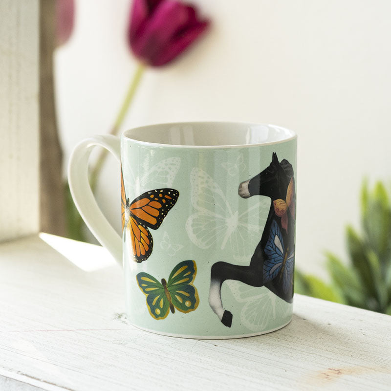 Mug with a design of a horse and butterflies on a light green background