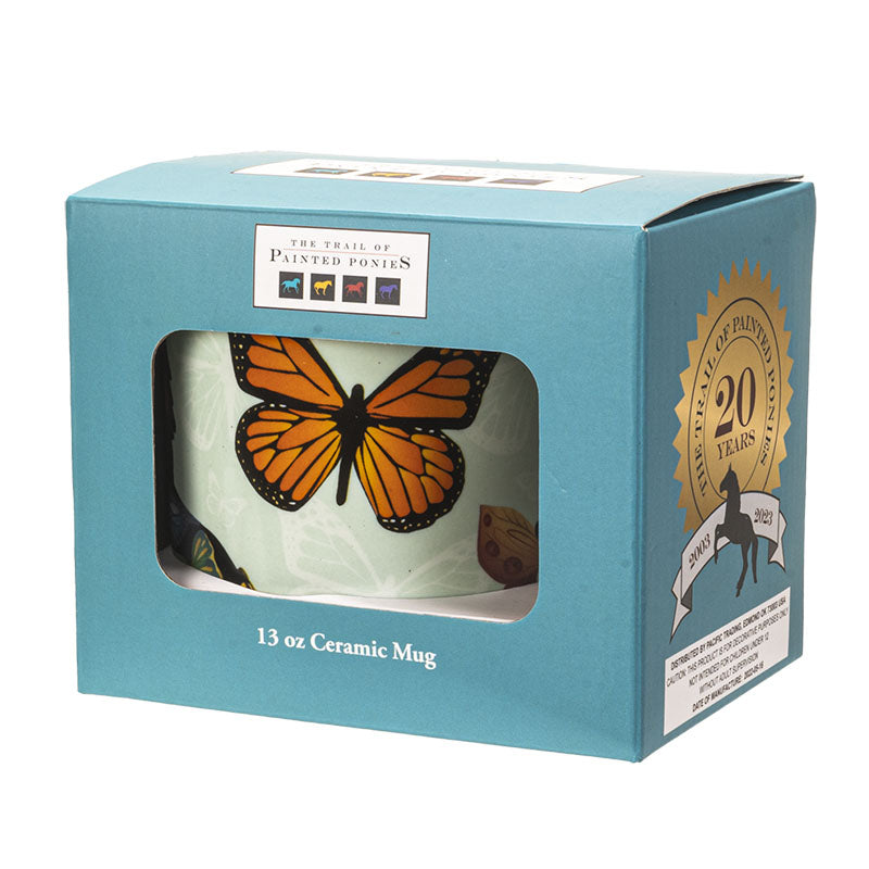 Ceramic mug with butterfly design in a blue packaging box labeled Trail of Painted Ponies