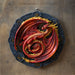 Beltane red and orange dragon on a black wheel with runic symbols, to hang on a wall