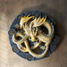 Imbolc dragon plaque showing yellow serpent dragon on a black wheel with runic symbols