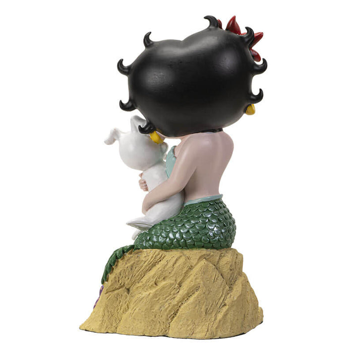 Figurine of Betty Boop as a mermaid with Pudgy the dog on the sand. Back view