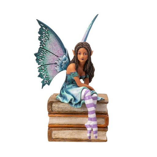 Figurine of a tanned skin fairy with brown braided hair and teal-purple wings in a blue-green dress, perched on a stack of tan books. Striped white and purple stockings.