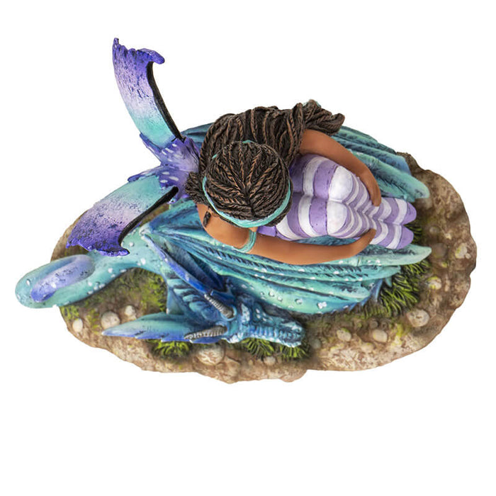 Top down view - Figurine of fairy with braided hair, aqua and purple outfit sitting with teal and blue dragon