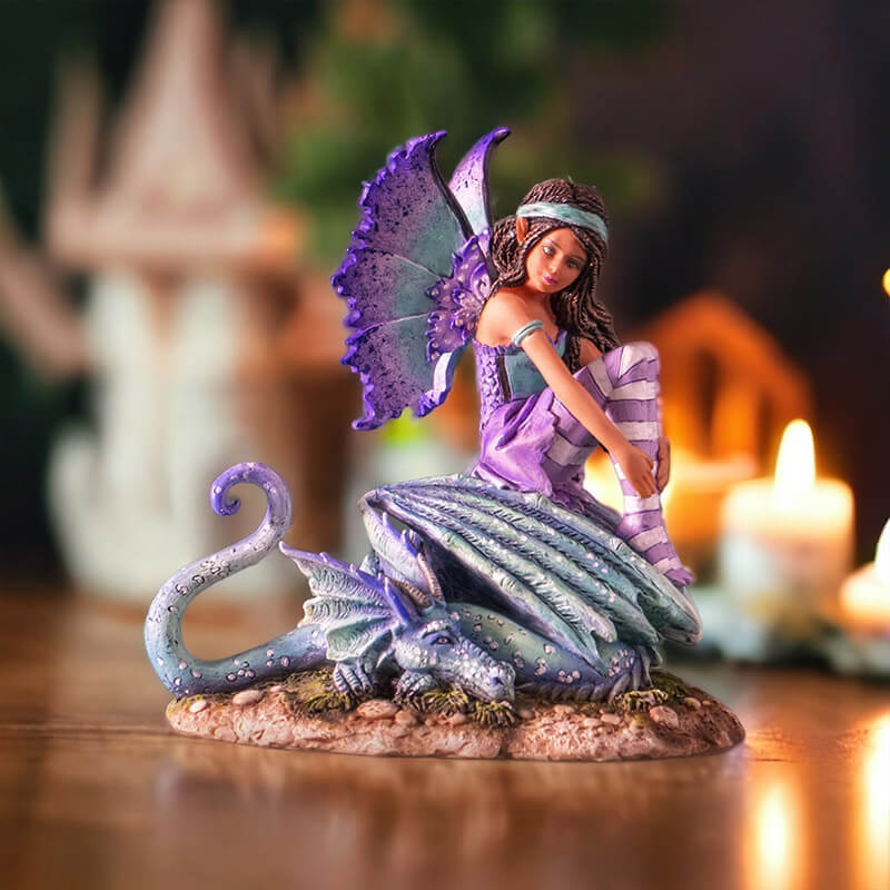 Figurine of fairy with braided hair, aqua and purple outfit sitting with teal and blue dragon