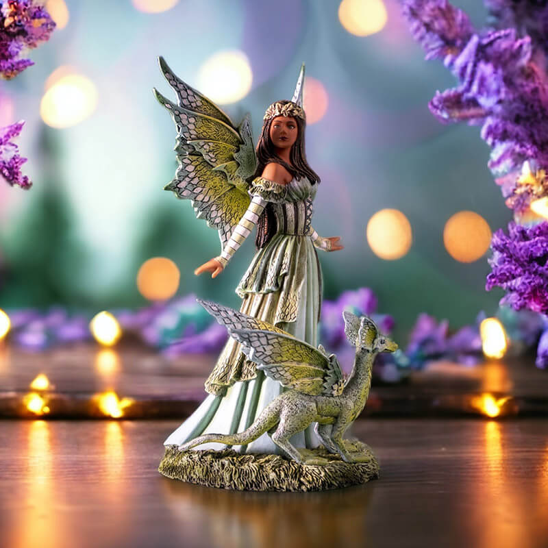 Figurine of a fairy dressed in green with matching wings and dragon. She has tanned skin and braided brown hair.