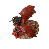 Figurine of tanned woman with dark hair standing with a knife, a red dragon perched on her shoulder. Shown top-down, with dragon wings spread