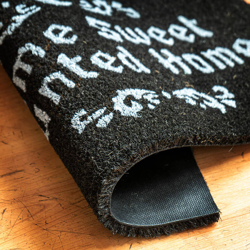 Doormat curled over to show coir coconut fiber top and PVC bottom