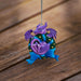 Ornament with purple and pink dragon in wreath with gold baubles and blue ribbon