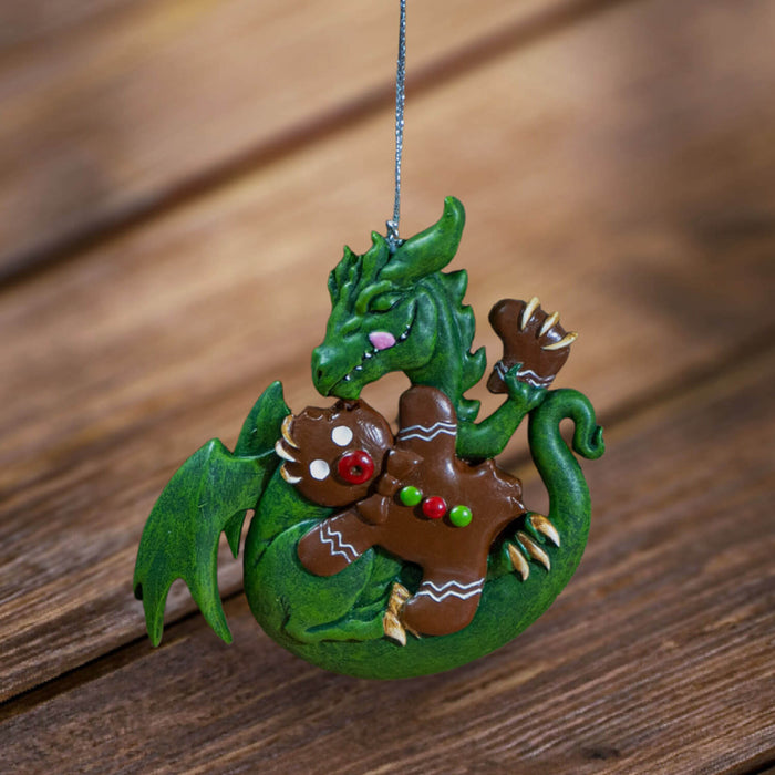 Ornament with green dragon munching on festive gingerbread man cookie