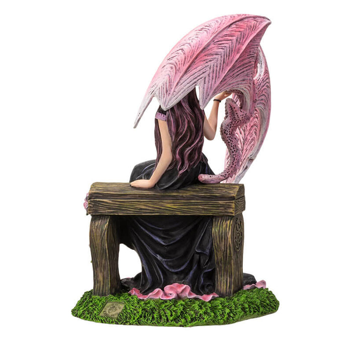 Back view - Figurine based on the artwork of Anne Stokes - woman in black and pink dress sitting on a bench with roses, holding the claw of a pink dragon
