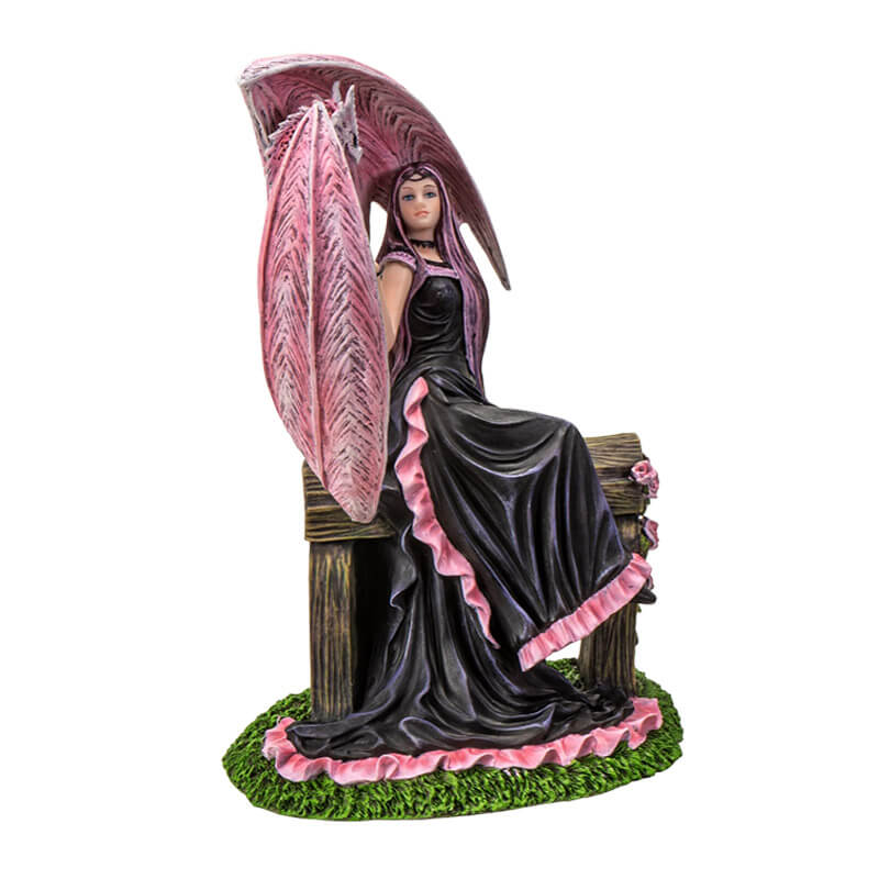 Figurine based on the artwork of Anne Stokes - woman in black and pink dress sitting on a bench with roses, holding the claw of a pink dragon