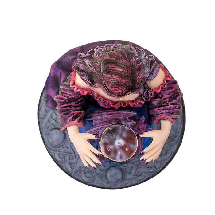 Top down view - Figurine by Anne Stokes of purple-clad sorceress looking into a crystal ball on a blue table, with a violet dragon curled around the ball's' base