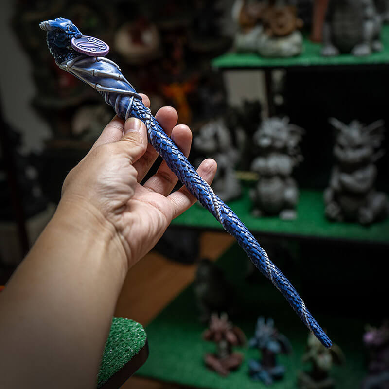 Magic wand with a dragon curled around it in shades of blue and purple with air emblem