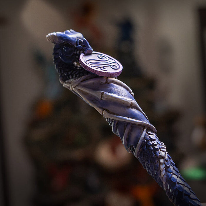 Magic wand with a dragon curled around it in shades of blue and purple with air emblem