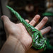 Magic wand in green of dragon spiraling down, holding leaf and mountain coin in mouth