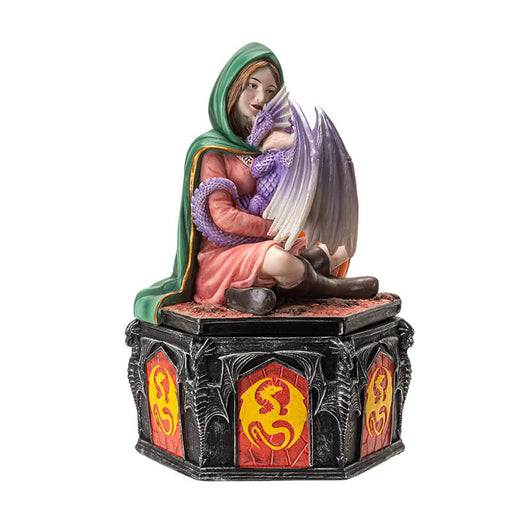 Trinket box, lid has a woman in a green cloak and pink dress cuddling a purple dragon, with a pumpkin. Outer rim of box has red and yellow dragon designs
