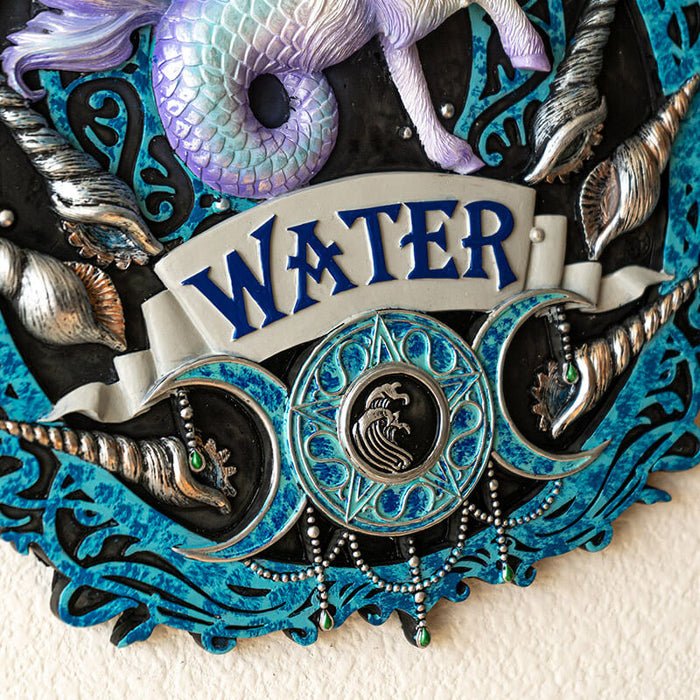 Closeup of "WATER" and silver seashells